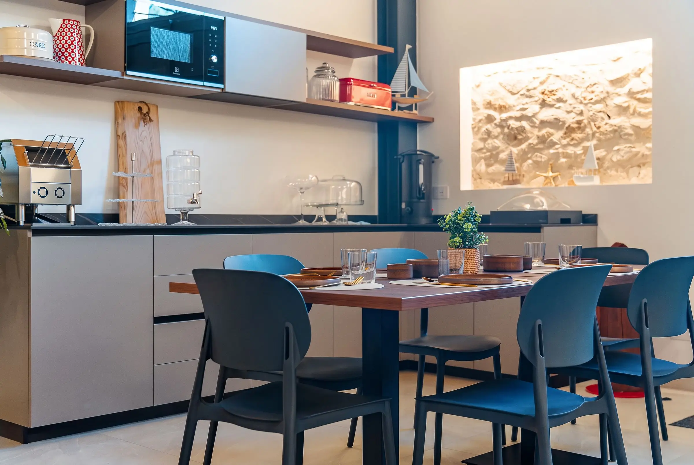 L’angolo cucina e i tavoli apparecchiati della sala colazione