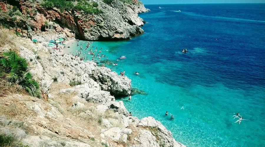 Una cala della riserva dello Zingaro, la scogliera e il mare che passa dal turchese al blu