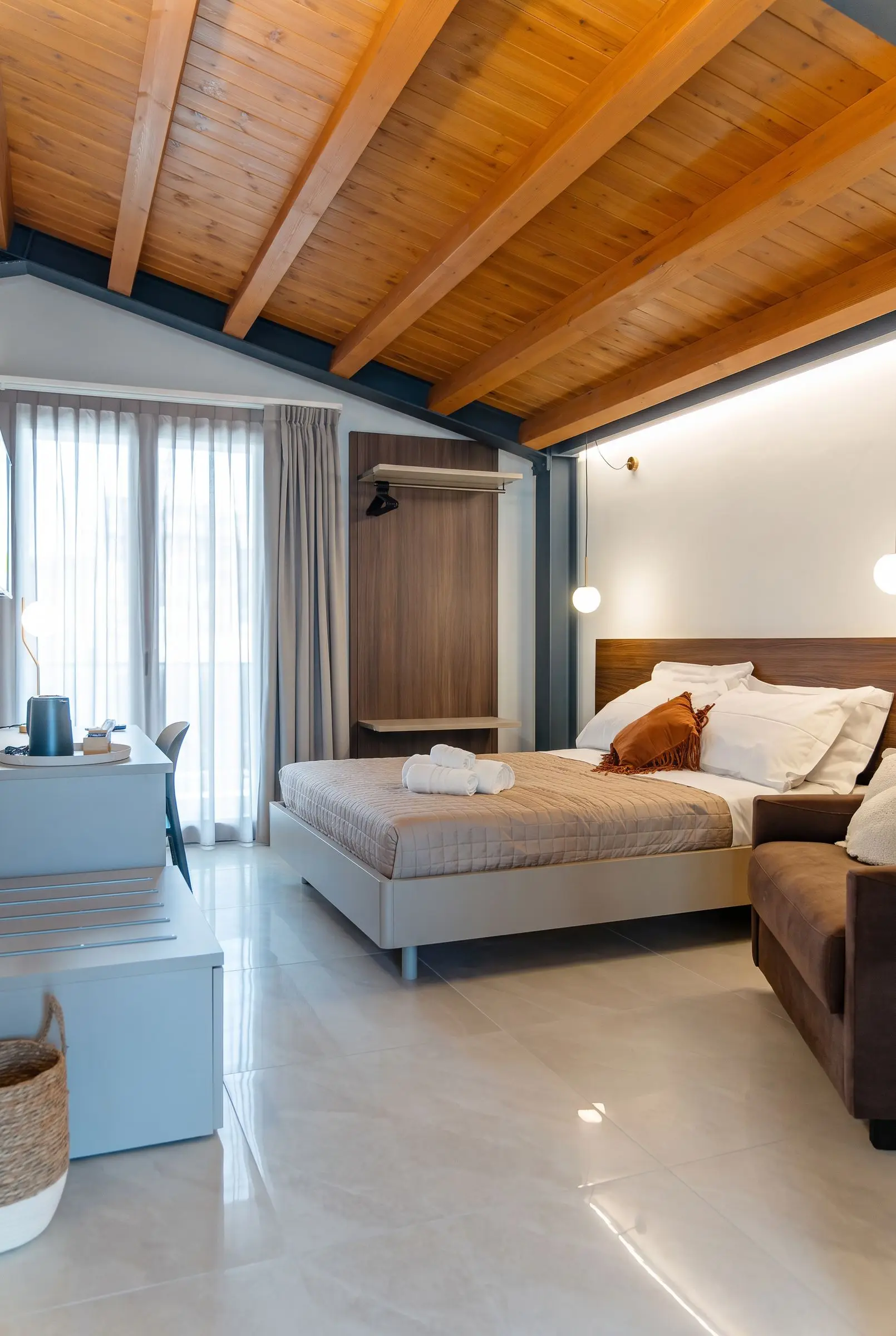 La camera Myrtus, le travi in legno e le putrelle blu