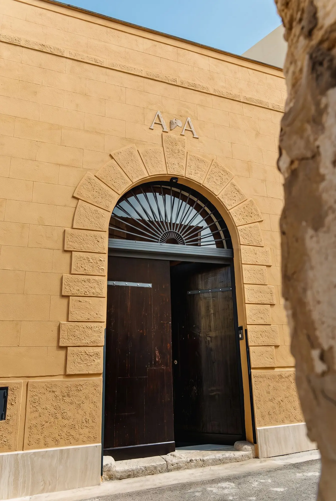 Il portone ad arco in legno visto dalla strada