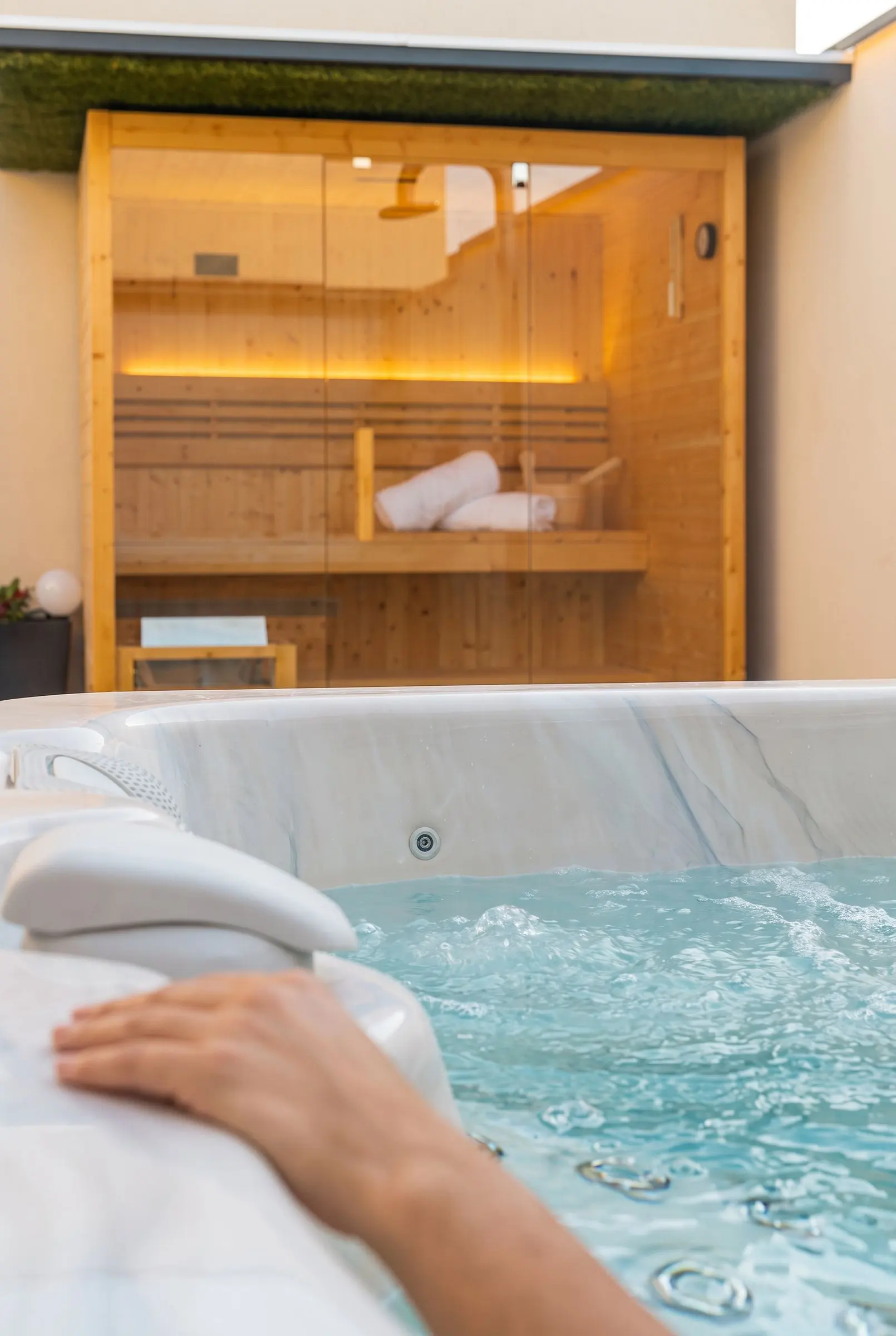 La vasca idromassaggio in terrazza, l’acqua in movimento e la sauna finlandese sullo sfondo